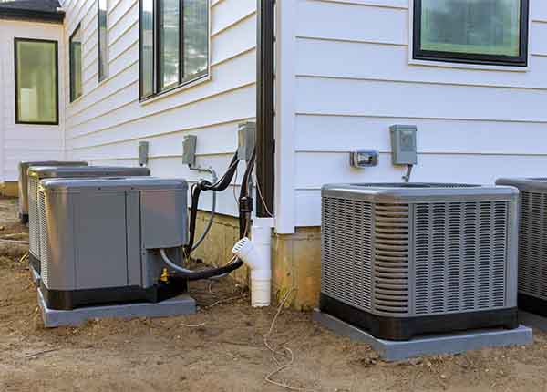 Multiple outdoor HVAC condenser units installed alongside a South Jersey home